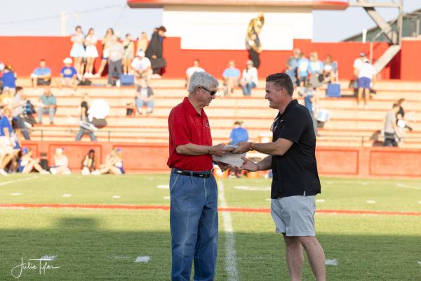 Loyd Benson (left) accepts a plaque from Clay Johnson (right) for his dedication to the Frederick Bombers for the last 46 years. Courtesy photo | Julie Tyler